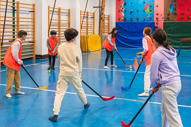 Youth playing floor hockey in gymnasium