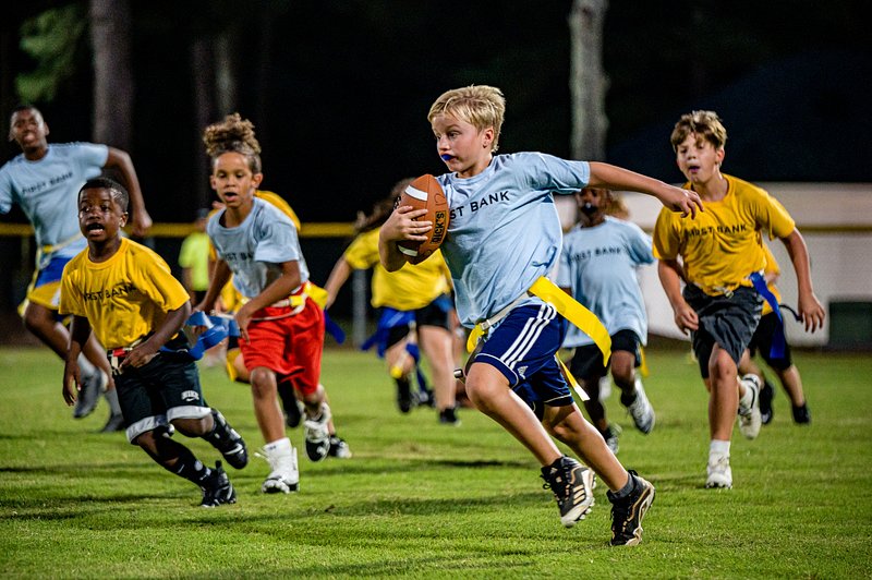 Youth football sprint with team flags on field